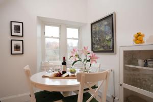 a dining room table with a bottle of wine and flowers at West Lodge - Seasgair Lodges in Kincraig