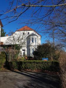 een groot wit huis met een rood dak bij Villa Elbblick mit Garten in Tangermünde