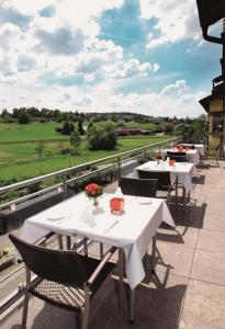 d'une terrasse avec des tables et des chaises et une vue sur un champ. dans l'établissement Wo der Hahn kräht, à Flein