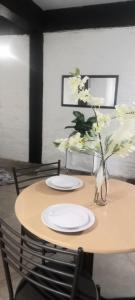 een tafel met twee borden en een vaas met bloemen bij Chic Urban Maboneng Getaway, Free Wi-Fi in Johannesburg