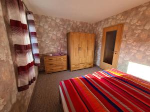 a bedroom with a bed and a wooden cabinet at Ferienwohnung Weber in Neustadt in Sachsen