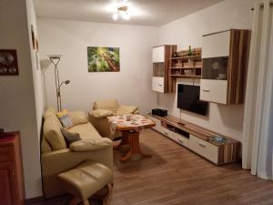 ein Wohnzimmer mit einem Sofa und einem Tisch in der Unterkunft Ferienwohnung Weber in Neustadt in Sachsen