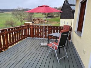 einen Tisch und Stühle auf einer Terrasse mit einem Sonnenschirm in der Unterkunft Ferienwohnung Weber in Neustadt in Sachsen