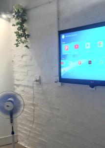 een flatscreen-tv aan een muur met een ventilator bij Chic Urban Maboneng Getaway, Free Wi-Fi in Johannesburg