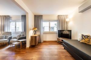 salon z kanapą i telewizorem z płaskim ekranem w obiekcie Vasari Apartment we Florencji