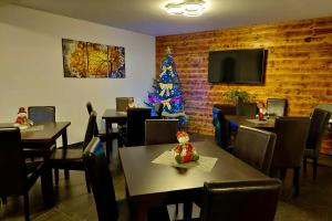 a dining room with a christmas tree in the corner at Casa Raisa in Buşteni