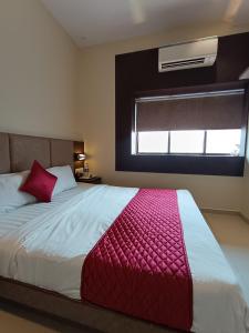 a bedroom with a large bed with a red blanket at Hotel West INN-Near Mumbai International Airport in Mumbai