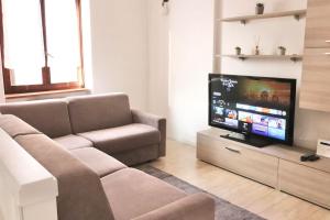 een woonkamer met een bank en een flatscreen-tv bij Chic and comfortable apartment in Verona in Verona