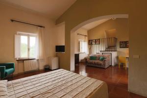 a bedroom with a bed and a living room at Hotel Pescille in San Gimignano