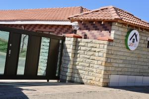 een gebouw met een poort en een bord erop bij Joy Guest House, Mabote in Maseru