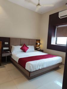 a bedroom with a large bed with a red blanket at Hotel West INN-Near Mumbai International Airport in Mumbai
