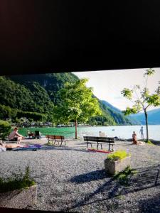 a group of people sitting on a beach near the water at 5 Personen Chalet am Luganer See in Porlezza