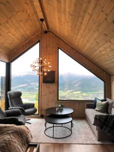 AlvdalにあるBaugsberget Fjelltopphytterのリビングルーム(ソファ、テーブル付)、大きな窓が備わります。 +21枚の写真