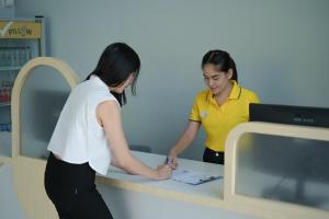 dos mujeres parados en un mostrador en una tienda en พิลโล่ อินน์ ฉะเชิงเทรา Pillow Inn Chachengsao, en Ban Khao Hin Son