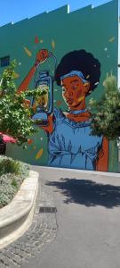 een muurschildering van een vrouw met een mobiele telefoon bij Chic Urban Maboneng Getaway, Free Wi-Fi in Johannesburg