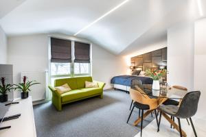 a bedroom with a bed and a green couch at K20 Apartamenty Łódź - Dostęp na Kod in Łódź