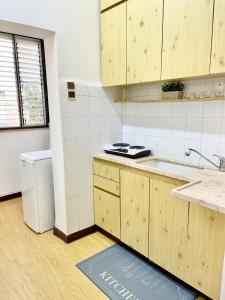 a kitchen with wooden cabinets and a sink at Bat Galim - Mirror Apartment by the beach in Haifa