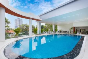 a large swimming pool with blue water in a building at Petro House Vung Tau in Vung Tau
