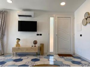 a living room with a tv on a wall at SUITE APARTMENTS BRANCO - Infinity Pool & Sea View in Taormina +11 photos