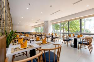 a restaurant with tables and chairs and large windows at Petro House Vung Tau in Vung Tau