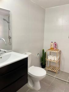 a white bathroom with a toilet and a sink at Bat Galim - Mirror Apartment by the beach in Haifa
