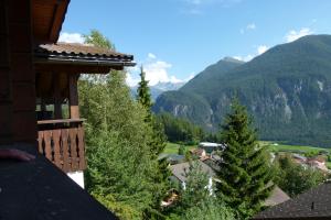 - un balcon avec vue sur une maison arborée dans l'établissement Ferienhaus Bensel, à Alvaneu