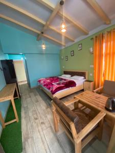 um quarto com uma cama, uma mesa e um sofá em JAYANTI MOTHER NATURE HOMESTAY MUNSYARI em Munsyari