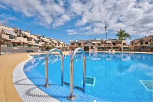 een groot zwembad met blauw water in een resort bij Apartamento Los Geranios in Arona