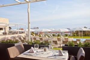 a restaurant with white tables and chairs and umbrellas at Seth 55 Santo Tomas in Santo Tomás