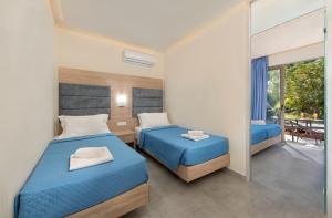 a bedroom with two beds and a balcony at Marathon Hotel - All Inclusive in Kolymbia