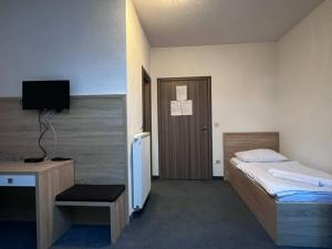 a bedroom with a bed and a desk and a television at Motel Papić in Tomislavgrad