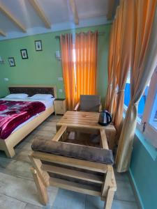 um quarto com uma cama, uma mesa de madeira e uma secretária em JAYANTI MOTHER NATURE HOMESTAY MUNSYARI em Munsyari