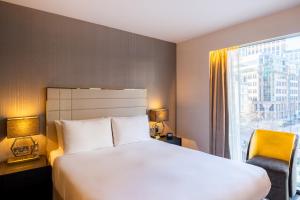 ein Hotelzimmer mit einem großen Bett und einem Fenster in der Unterkunft Hotel Saint London in London