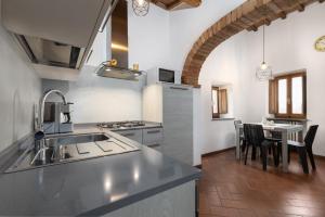 cocina con fregadero y mesa con sillas en La Badia en Gambassi Terme