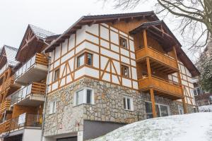 uma grande casa de madeira com uma fachada de pedra em APARTAMENTY Słowackiego 5b, Karpacz em Karpacz