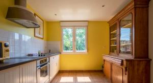 eine Küche mit gelben Wänden und einem Herd in der Unterkunft Maison de 3 chambres avec jardin clos et wifi a Moussy in Moussy