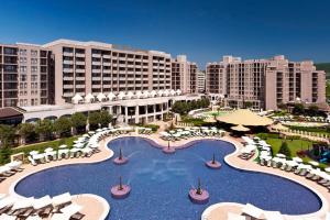 un complexe doté d'une grande piscine avec des chaises et des parasols dans l'établissement Barcelo Royal Beach Private Apartament, à Sunny Beach