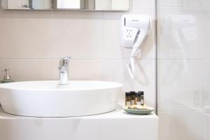 a bathroom with a white sink and a phone at RIVIERA HOTEL in Xylokastron