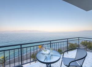 balcón con mesa, sillas y vistas al océano en RIVIERA HOTEL en Xylokastro