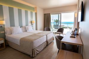 a hotel room with a bed and a desk and a balcony at Seth Santo Tomás in Santo Tomás