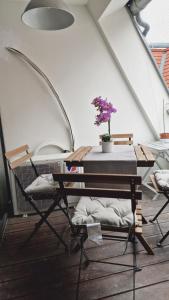- une table et des chaises dans une pièce dotée d'une plante dans l'établissement Elegance Apartment, à Vienne