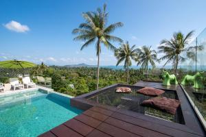 a villa with a swimming pool and palm trees at Monkey Villa Chaweng Noi koh samui in Koh Samui 