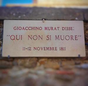 a sign on the side of a brick wall at Serra Marina Rooms and Apartments in Santa Maria di Castellabate