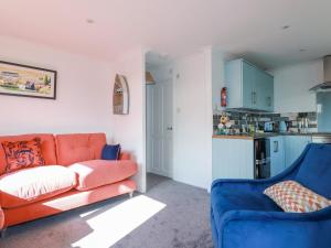 een woonkamer met een oranje bank en blauwe stoelen bij Hebask in Saint Day
