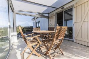 a wooden table and two chairs on a balcony at Jolie maison et sa véranda pour de belles vacances in Saint-Philibert