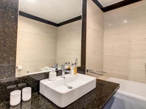 a bathroom with a white sink and a bath tub at Over the Cliff Apartment by LovelyStay in Funchal +43 photos