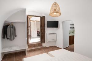 a dressing room with a mirror and a tv at Madame Kalitsi Cozy Suites in Fira