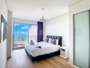 a bedroom with a large bed and a large window at Over the Cliff Apartment by LovelyStay in Funchal