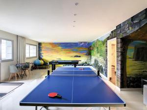 a ping pong table in a room with a painting at Over the Cliff Apartment by LovelyStay in Funchal