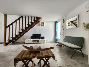 a living room with a table and a staircase at CASSIOPEE in Saint-Gilles les Bains